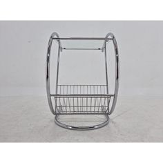 a metal wire basket on the side of a white wall