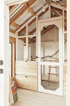 the inside of a chicken coop with wooden floors and walls, including an open door