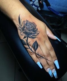 a woman's hand with a rose tattoo on it