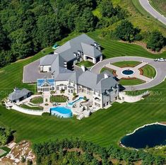 an aerial view of a large mansion with a swimming pool in the middle of it