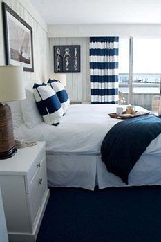 a bedroom with blue and white decor on the walls, carpeted flooring and bedding