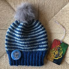 a blue and white knitted hat next to a harry potter badge