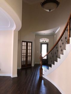 an entryway with wooden floors and railings leading up to the second story door