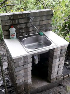 a sink built into the side of a brick wall with a faucet attached to it