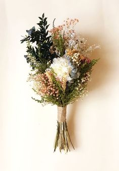 a bouquet of flowers sitting on top of a white wall