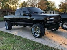 a black truck parked on top of a sidewalk