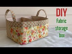 the fabric storage box is sitting on top of a white bed with flowers and polka dots