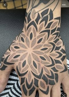 a person's hand with a tattoo on it and a flower design on the palm