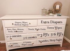 a white dresser with extra diapers written on the top and bottom drawers in different sizes