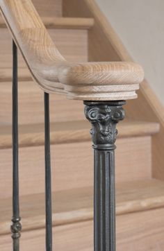 an iron and wood stair railing with wooden handrails on the bottom part of stairs