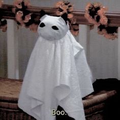 a white towel hanging from a rack with flowers in the corner and an image of a ghost on it