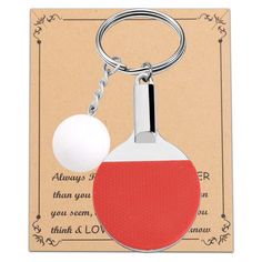 a red and white ping pong paddle keychain with a ball on it