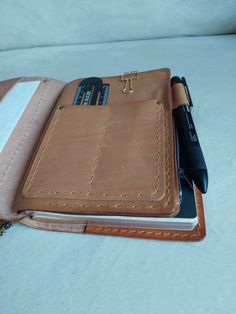 an open notebook and pen sitting on top of a bed