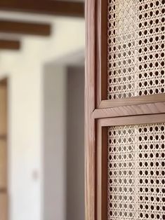 a close up of a wooden frame with holes in the wood and white wall behind it