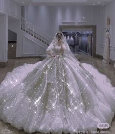 a woman in a white wedding dress standing next to a staircase with lights on it