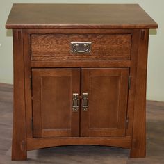 a small wooden cabinet with two doors on the front and one drawer at the bottom