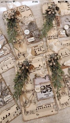 several pieces of paper with christmas decorations on top of sheet music notes and evergreen branches