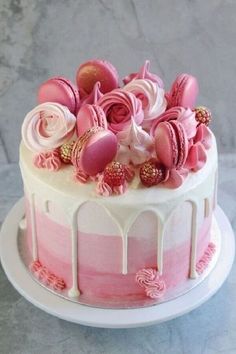 a pink and white cake with frosting on top