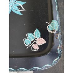 a black tray with blue and pink flowers on it