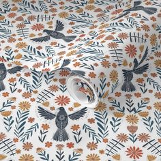 an orange and blue bird pattern on white fabric, with small flowers in the background