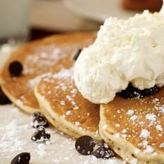 three pancakes topped with whipped cream and chocolate chips