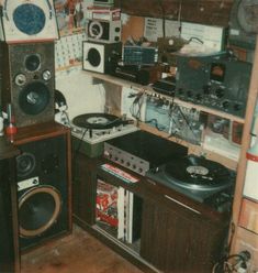 a room filled with lots of electronics and sound equipment on top of wooden shelves next to each other