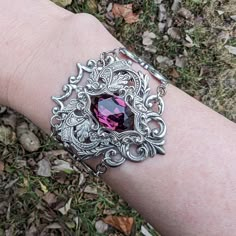 "This unique Amethyst bracelet is made with sterling silver plated brass vintage stampings that form a gothic/fantasy look.  The center 16x11mm stone is a vintage Swarovski crystal (no longer in production).  The bracelet measures 2\" tall and 7.5\" long, which will fit most women's wrists.   I offer two options for the closure:   1. A steel slider chain that is easy to adjust and secure.   2. A sterling silver plated brass cable chain with a lobster claw closure.  You can move the claw to any chain link to tighten. If you need longer chain, then please let me know, and I can make a special order for you! Your treasure will promptly ship from the United States and in a complimentary gift box." Fantasy Style Silver Bracelet, Fantasy Bracelet, Purple Gothic, Tech Jewelry, Diamond Pendants Designs, Edgy Jewelry, Edwardian Jewelry, Goth Jewelry, Fine Silver Jewelry