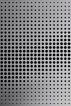 a metal surface with black dots on it