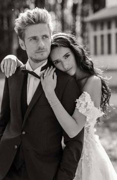 black and white photograph of a bride and groom hugging each other in front of a building