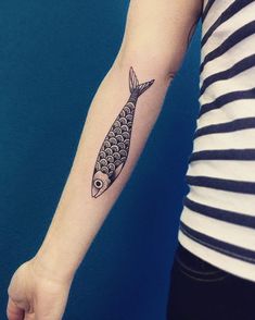 a woman's arm with a fish tattoo on it