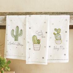 two towels hanging on a clothes line with cactus designs