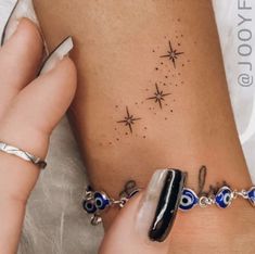 a woman's foot with a tattoo on it and stars in the sky behind her