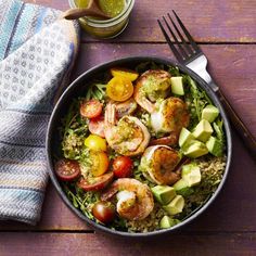 a salad with shrimp, tomatoes, avocado and lettuce in a bowl