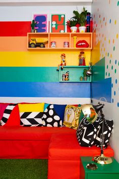 a brightly colored living room with colorful walls and shelves on the wall, painted in rainbow colors