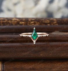 an emerald colored ring with diamonds on top