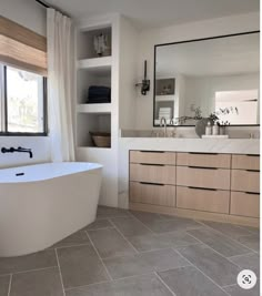 a bathroom with a large tub, sink and window in it's center area