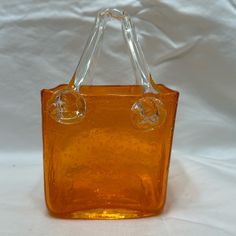 an orange glass bag with two clear handles