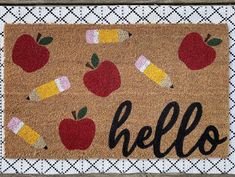 a door mat with an apple and candy on it that says,'hello '