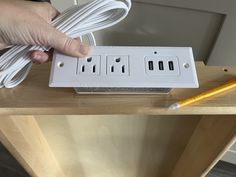 a person is plugging in to an electrical outlet on a table with a pencil