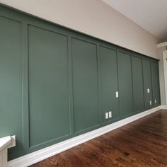 empty room with green walls and wood flooring