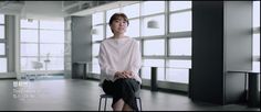 a woman sitting on top of a chair in an empty room