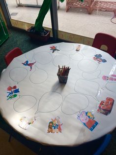 a white table topped with lots of stickers next to a green slide in the background