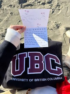 someone holding up a piece of paper with the ubc on it