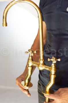 a man is holding two faucets in his hands