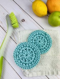 two crocheted hearts on a towel next to lemons and a green brush