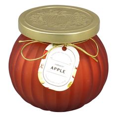 an apple shaped jar with a tag on the lid and gold trimming around it