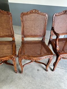 three wicker chairs sitting next to each other on the floor in front of a wall