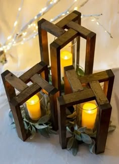 three wooden blocks with candles in them on a table