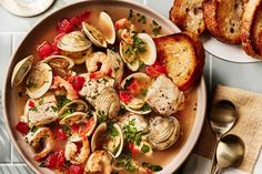 a bowl of clams and bread on a table