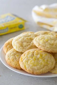 lemon cookies on a white plate next to a carton of buttermilks